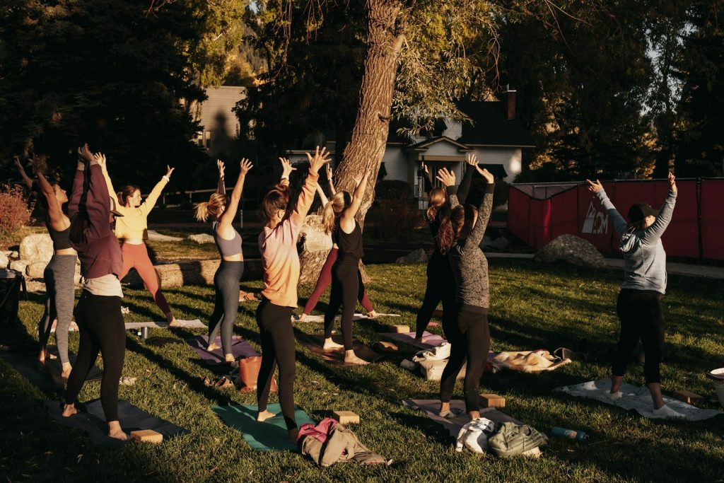 a group of people doing yoga in a park